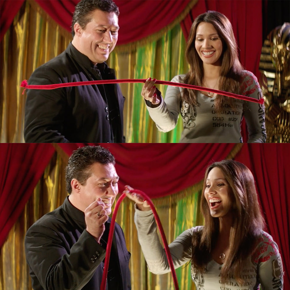 Two people playing with a red rope against a colorful curtain background